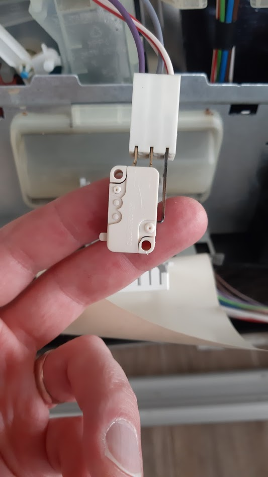 white microswitch, dissasembled dishwasher in the back
